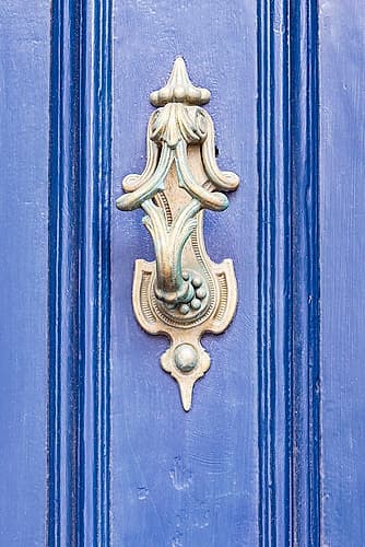 Lindisfarne, Holy Island, Berwick-upon-Tweed, Northumberland, England. Brass knocker on a blue door Art Print